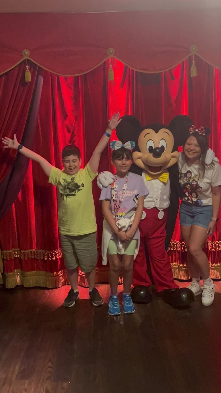 Lucca with his arms in the air, meeting Mickey with friends