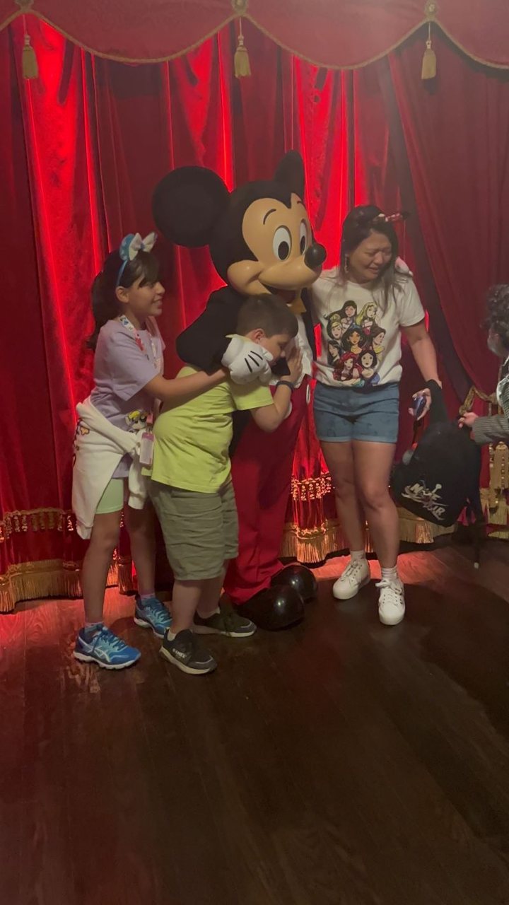 Lucca hugging Mickey, with friends beside him