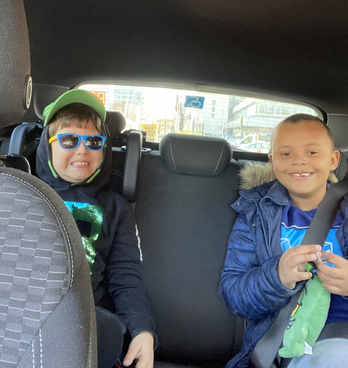 Lucca in sunglasses and Roman smiling in the back of a car