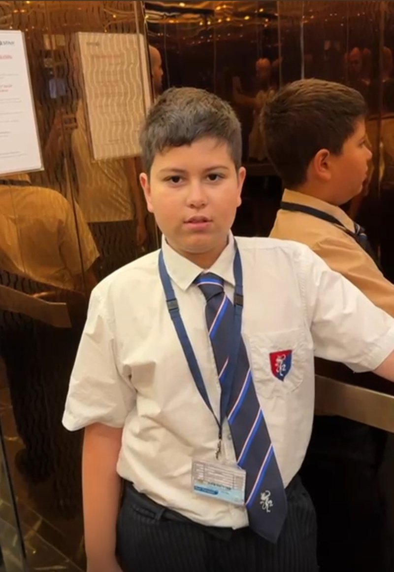 Lucca in his school uniform, with his tie and lanyard