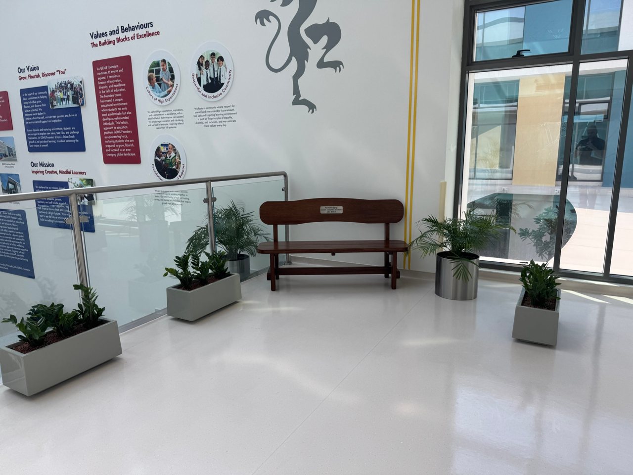 The bench in the school hallway, under the school's vision and values wall