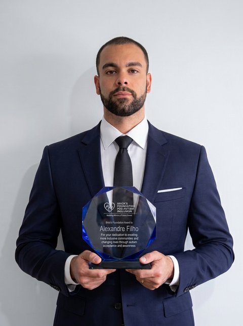 Alexandre Filho holding a Brick's Foundation award