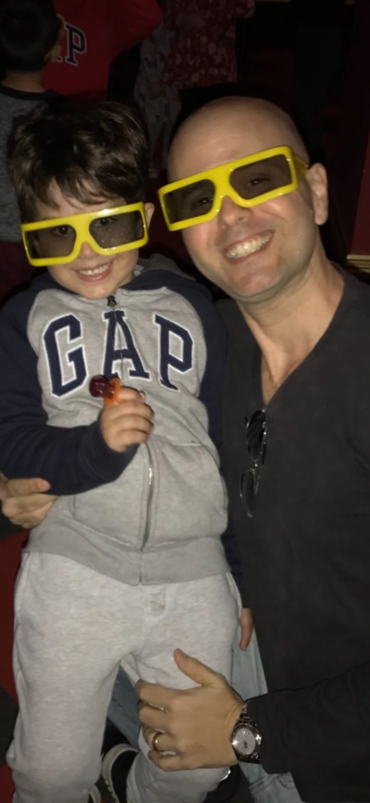 Aloisio smiling with Lucca, both wearing big yellow 3D glasses