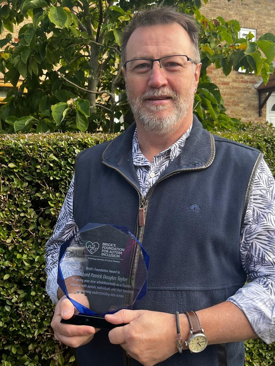 Richard Taylor smiling, holding his Brick's Foundation crystal award